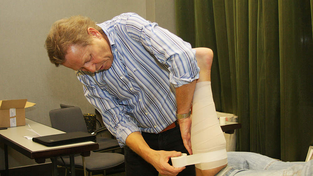 DFB-Physiotherapeut Klaus Eder beim Tapen einer Muskelverletzung an der Wade! © Sven Hehl